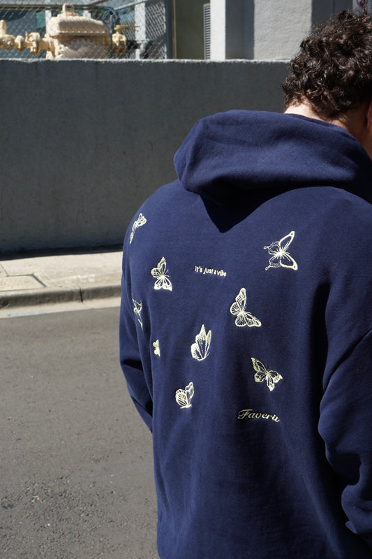 Model wearing Navy hoodie with embroidered lemon butterflies